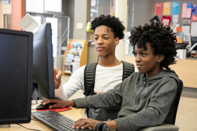 two teens at a computer