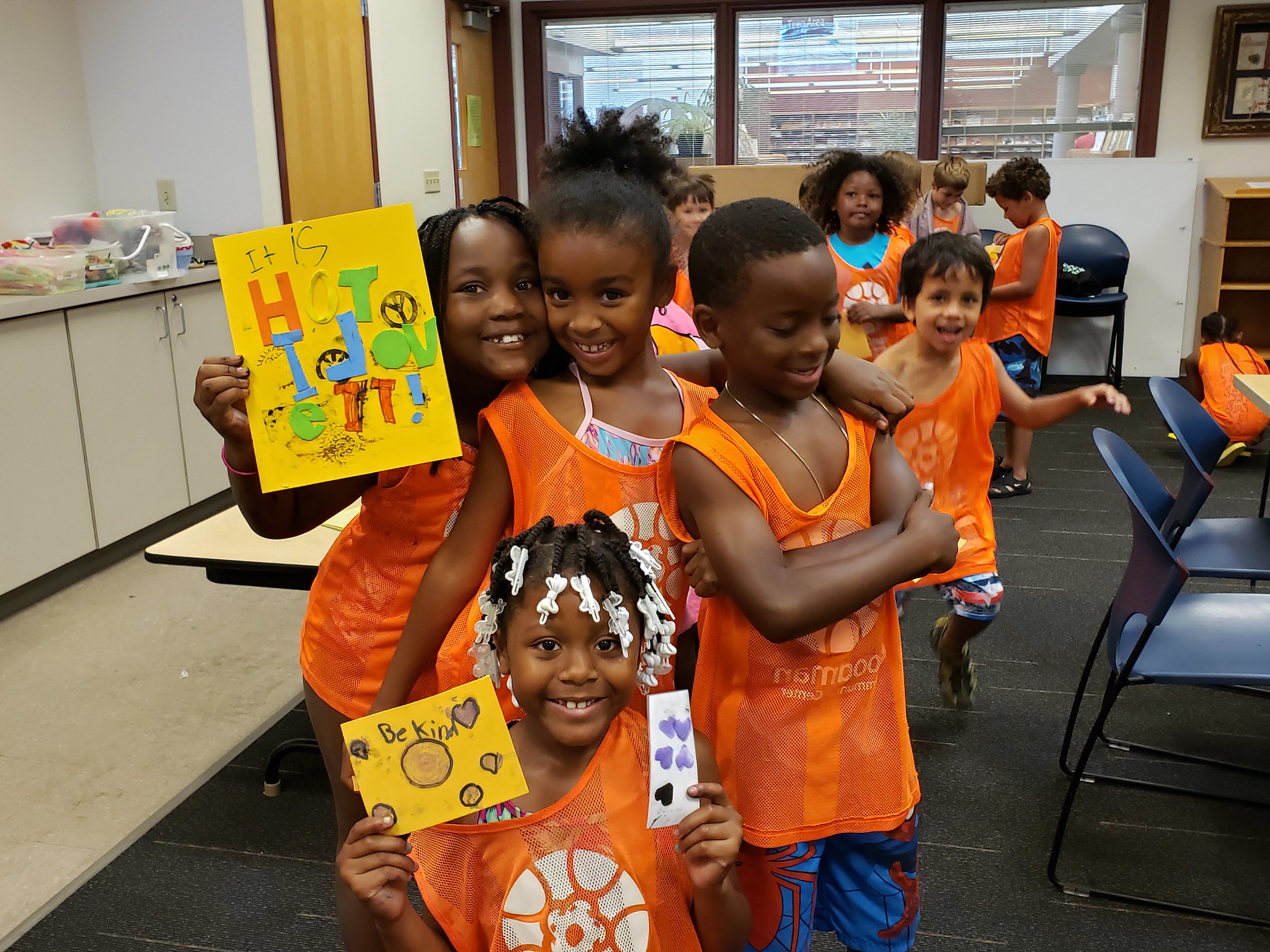 Kids hold up their stamp-making creations 