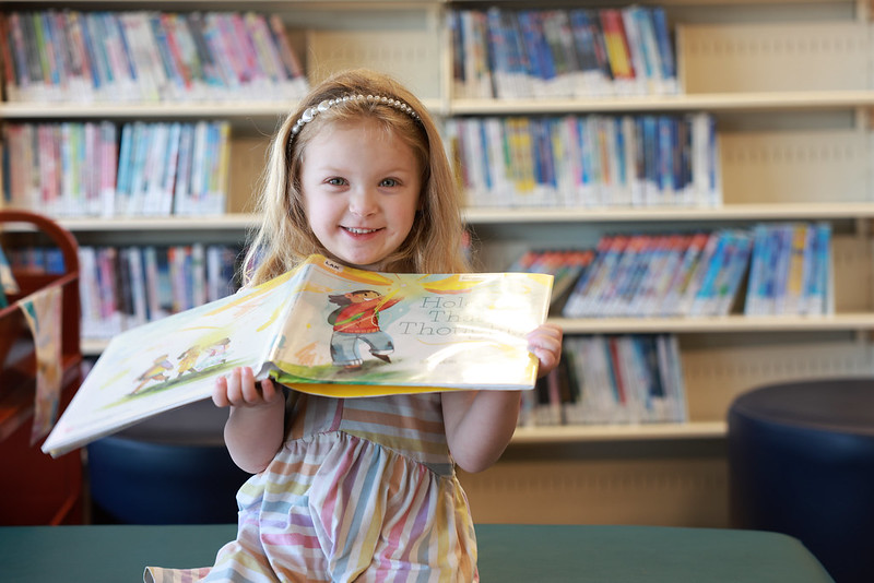 Kid reading in the library we read