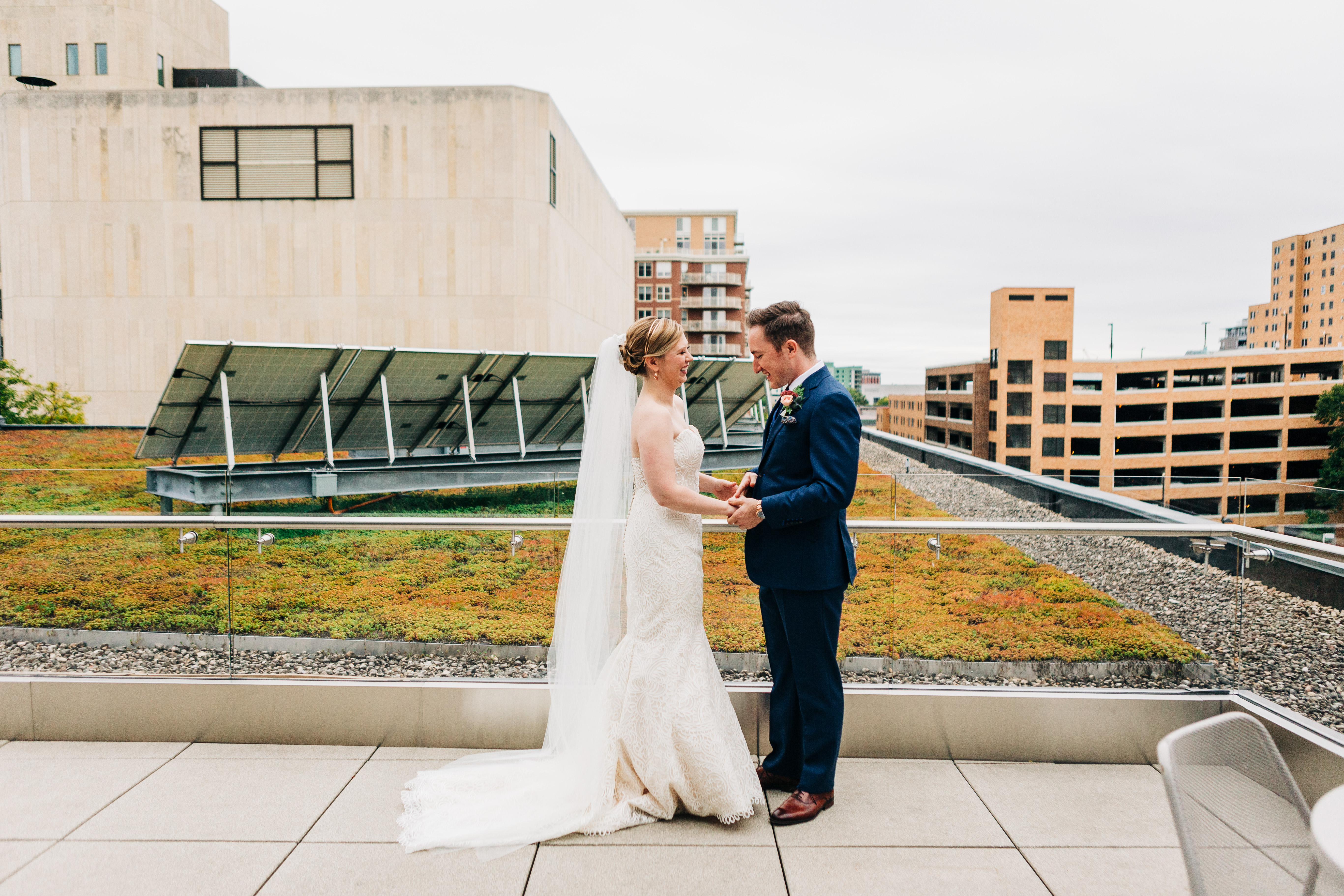 bride and groom posing in front of green roof