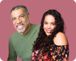 Shelene and Hiram pose together, smiling, in front of a rose colored background